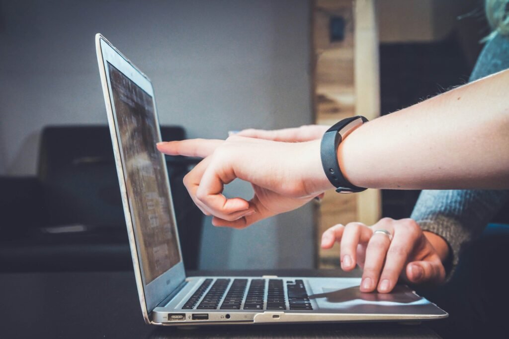 Two professionals collaborating on a laptop screen, discussing construction or interior design project details in an office setting.